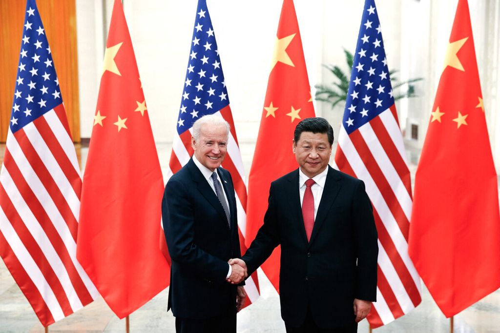 Dalam foto yang diambil pada Desember 2013 ini, Presiden China Xi Jinping berjabat tangan dengan Wakil Presiden Amerika Serikat Joe Biden yang kini sudah menjadi presiden, di Beijing. 