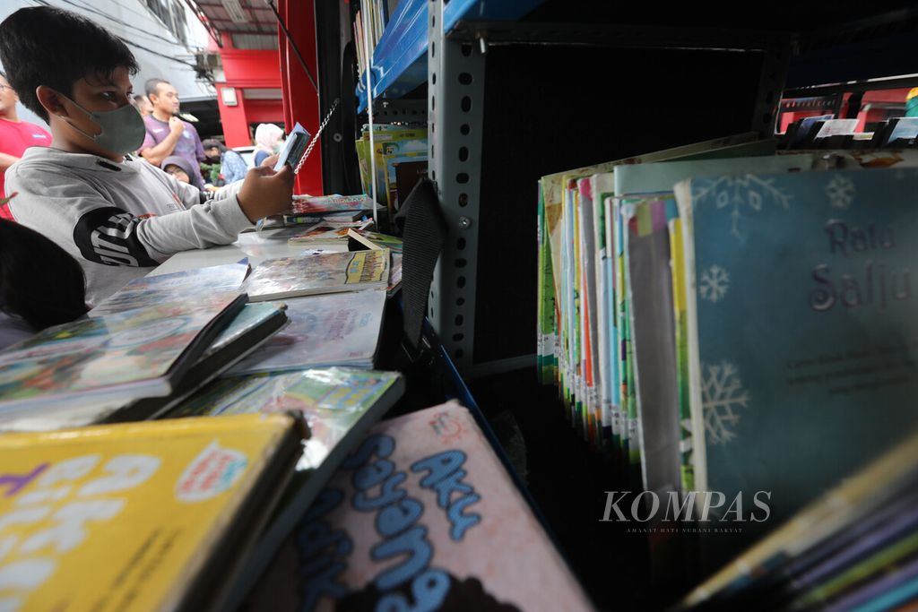 Seorang anak memilih buku saat mobil perpustakaan keliling Sudin Perpustakaan dan Kearsipan Jakarta Timur hadir pada hari bebas kendaraan bermotor (HBKB) di Jalan Pemuda, Jakarta, Minggu (29/1/2023). 