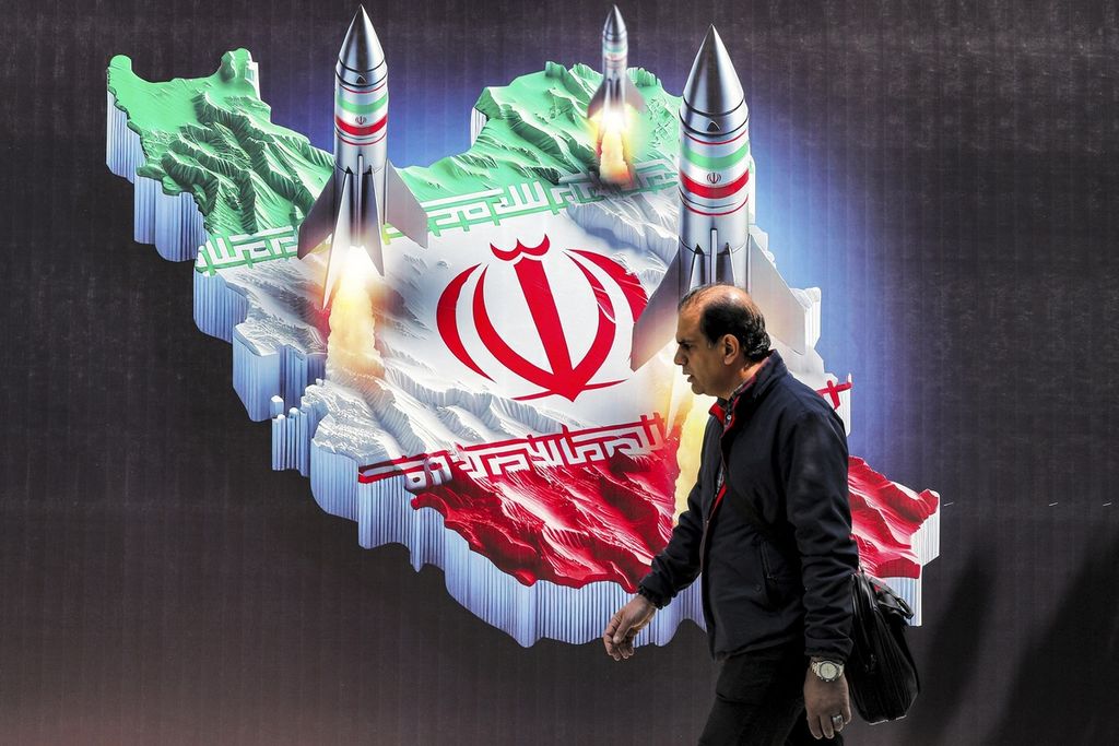 A man walks past a billboard in Tehran, Iran, depicting an Iranian missile attack, Monday (15/4/2024).
