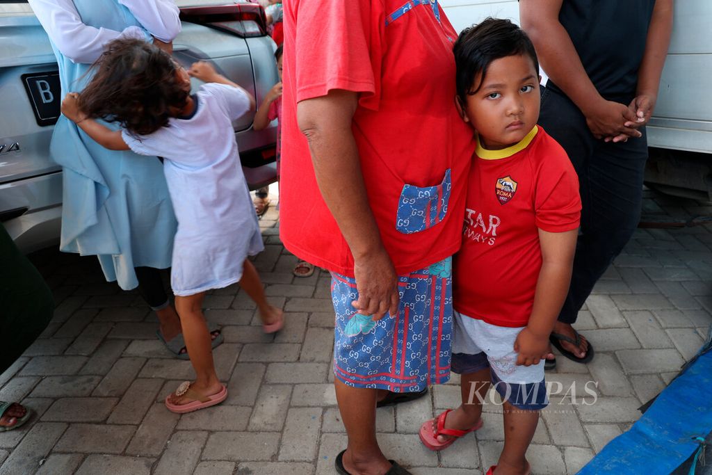 Orangtua mengantarkan anaknya menerima bantuan donasi dari Dana Kemanusiaan Kompas di Kampung Nelayan Tambakrejo, Kota Semarang, Jawa Tengah, Rabu (27/7/2022). 