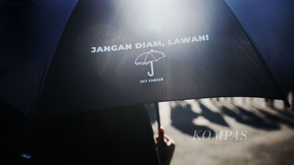 Seorang aktivis memegang payung khas aksi mengikuti Aksi Kamisan ke-767 di depan Istana Merdeka, Jakarta, Kamis (9/3/2023). 