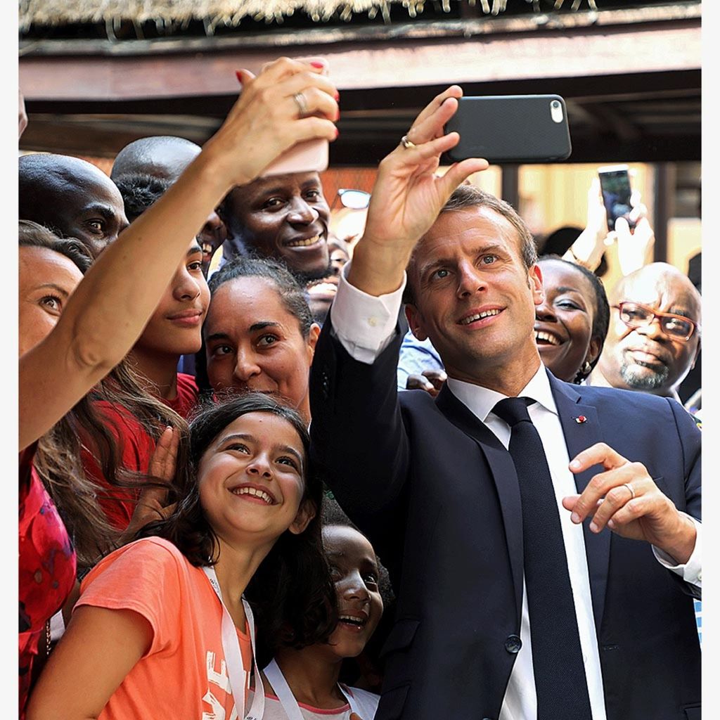 Presiden Perancis Emmanuel Macron berswafoto dalam kunjungan ke sekolah menengah atas Perancis Louis Pasteur di Lagos, Nigeria, Rabu (4/7/2018).