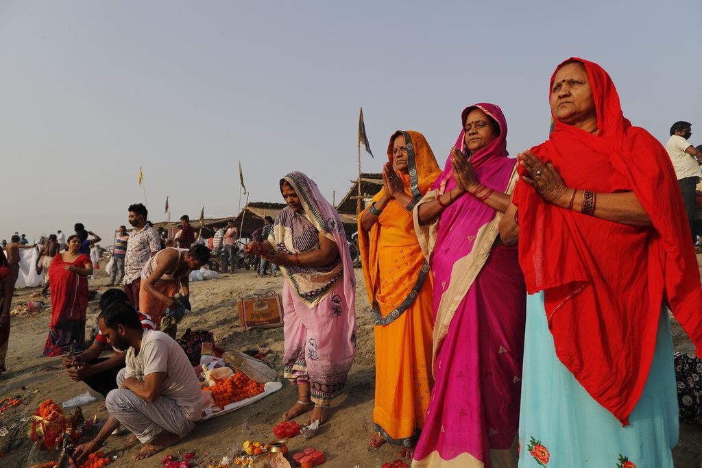 Umat Hindu melakukan ritual pagi di Sangam, pertemuan Sungai Gangga dan Yamuna, pada hari pertama Festival Navratri di Prayagraj, Uttar Pradesh, India, Selasa (13/4/2021). Navratri berlangsung selama sembilan hari, dengan tiga hari masing-masing dikhususkan untuk memuja dewi keberanian Durga, dewi kekayaan Laksmi, dan dewi ilmu pengetahuan Saraswati. 