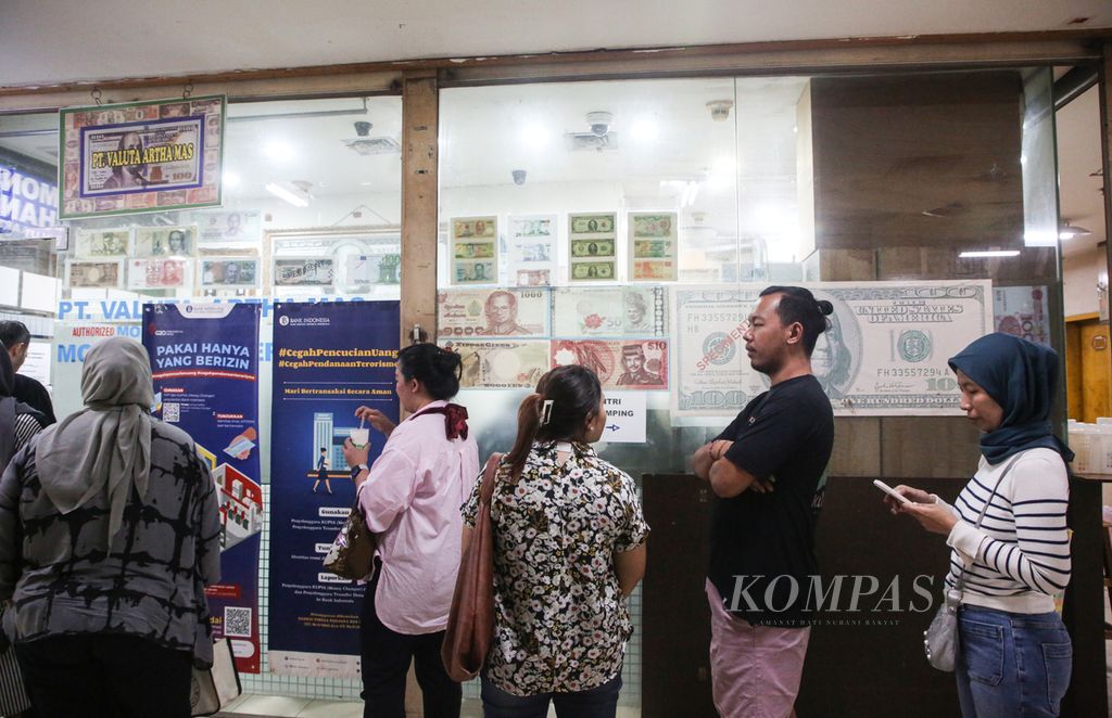 Antrean masyarakat yang hendak melakukan transaksi di PT Valuta Artha Mas di Jakarta, Selasa (16/4/2024). Petugas mengakui jumlah masyarakat yang melepas dollar AS-nya meningkat karena penguatan nilai tukarnya terhadap rupiah.