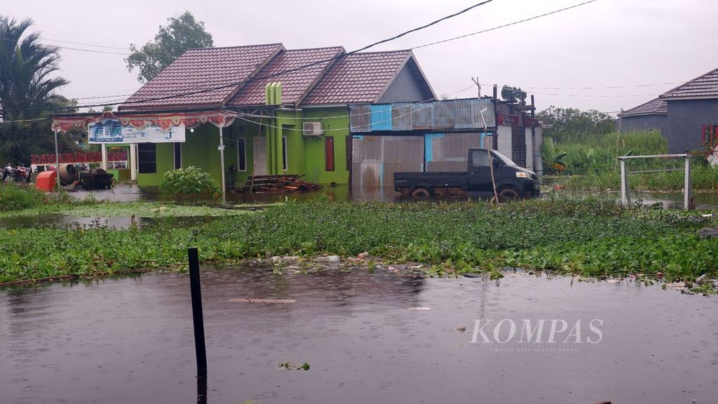 Banjir merendam salah satu kompleks perumahan warga di Kelurahan Sungai Lulut, Kecamatan Banjarmasin Timur, Kota Banjarmasin, Kalimantan Selatan, Jumat (15/1/2021). Banjir terjadi sejak Kamis karena tingginya intensitas curah hujan.