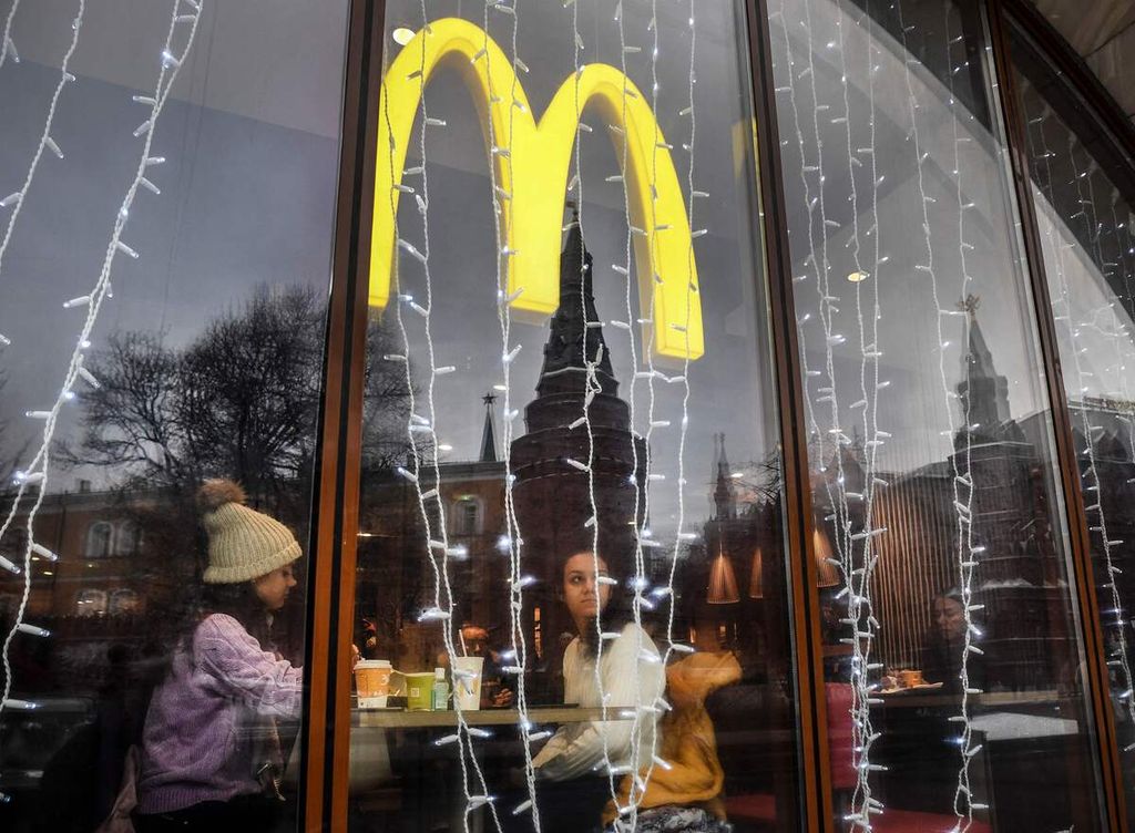 Foto yang diambil pada 30 Januari 2020 ini menunjukkan warga di restoran McDonalds. Refleksi menara Kremlin tampak pada kaca bangunan. Menyusul hujan sanksi dari Amerika Serikat dan negara sekutu, sejumlah perusahaan transnasional menutup usahanya di Rusia, mulai dari Apple hingga Levis, Sebagian perusahaan lagi memilih tetap bertahan. 