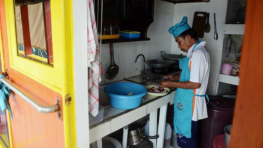 Nasir, juru masak kapal Gurano Bintang, memasak saat kapal tersebut berlabuh di perairan  Kwatisore, Distrik Yaur, Kabupaten Nabire, Papua, Selasa (15/8).