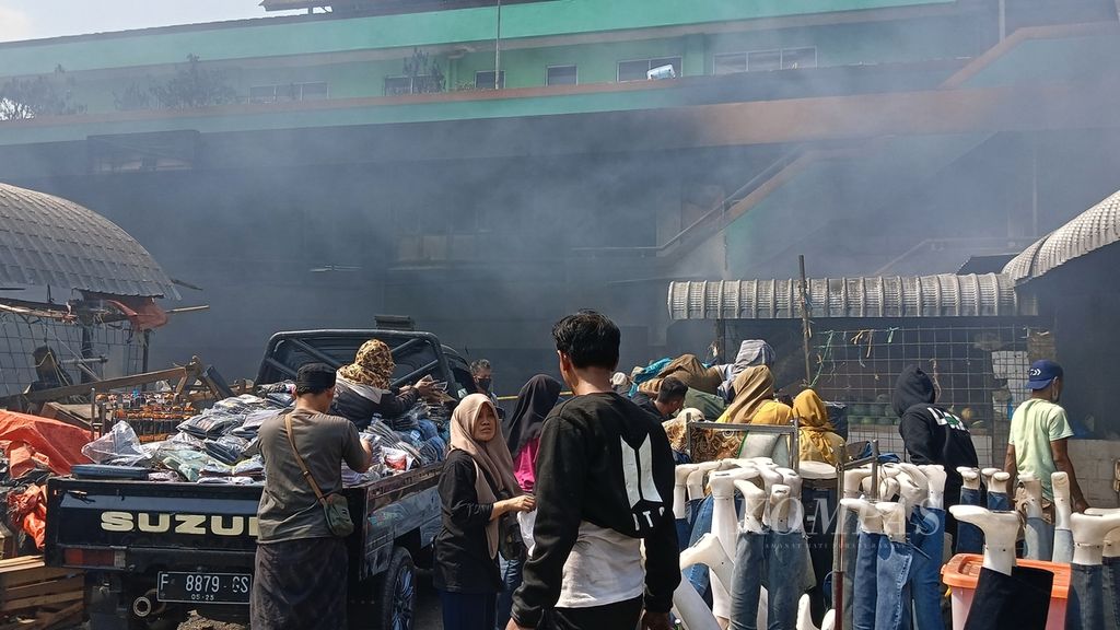 Sejumlah pedagang Pasar Leuwiliang, Kabupaten Bogor, Jawa Barat, sibuk memindahkan dagangannya dari kebakaran, Kamis (28/9/2023). Ribuan lapak di pasar Leuwiliang terbakar pada Rabu (27/9/2023) malam.