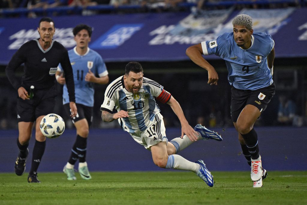 Bek Uruguay, Ronald Araujo (kanan),  melakukan pelanggaran terhadap penyerang Argentina, Lionel Messi (kiri), pada pertandingan sepak bola kualifikasi Piala Dunia Zona Amerika Selatan 2026 antara Argentina dan Uruguay di Stadion La Bombonera di Buenos Aires, Argentina, Jumat (17/11/2023). 