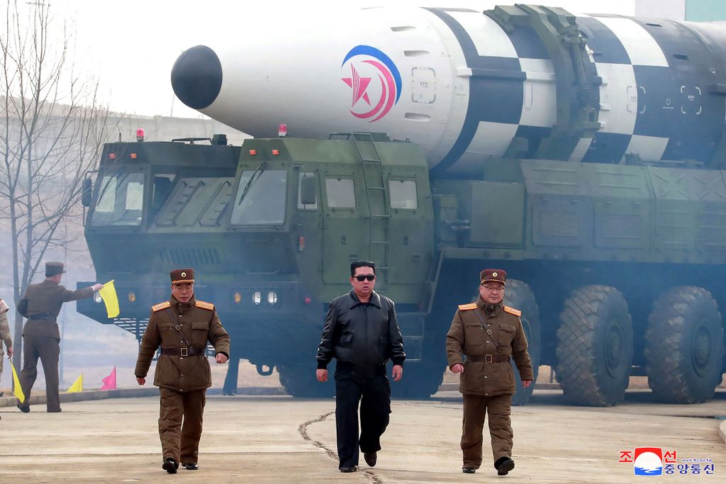 Pemimpin Korea Utara Kim Jong Un (tengah) berjalan di dekat rudal balistik antarbenua (ICBM), Hwasong-17, di lokasi yang dirahasiakan, 24 Maret 2022. 