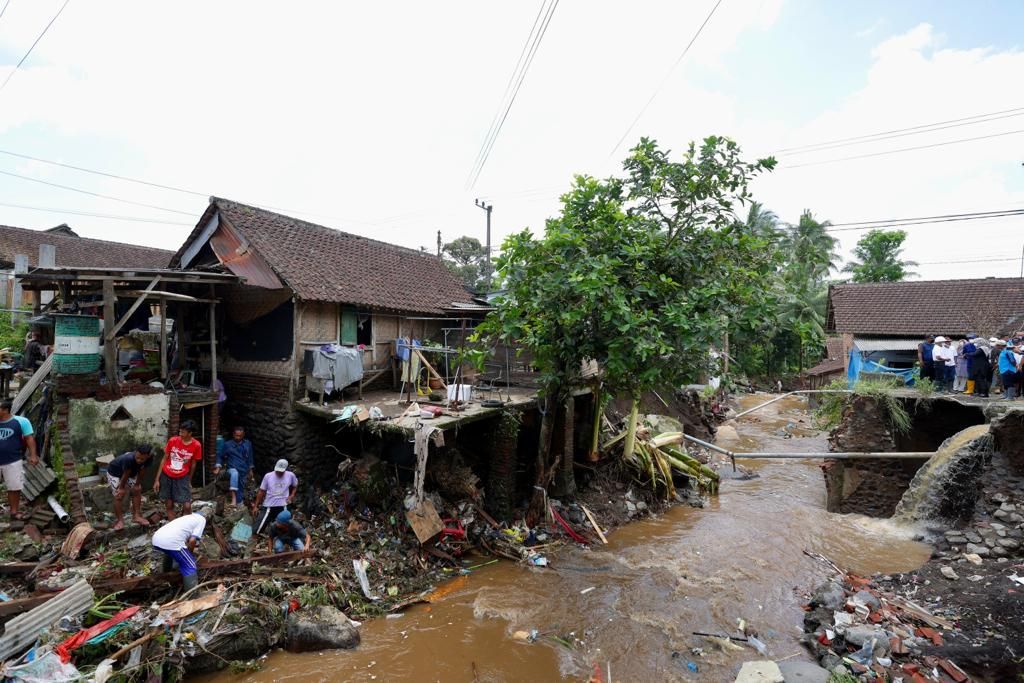Kondisi pascabanjir di Desa Kalibaru Wetan, Kabupaten Banyuwangi, Jawa Timur,  Jumat (4/11/2022) siang. Warga bergotong royong menyingkirkan sisa material yang menumpuk.