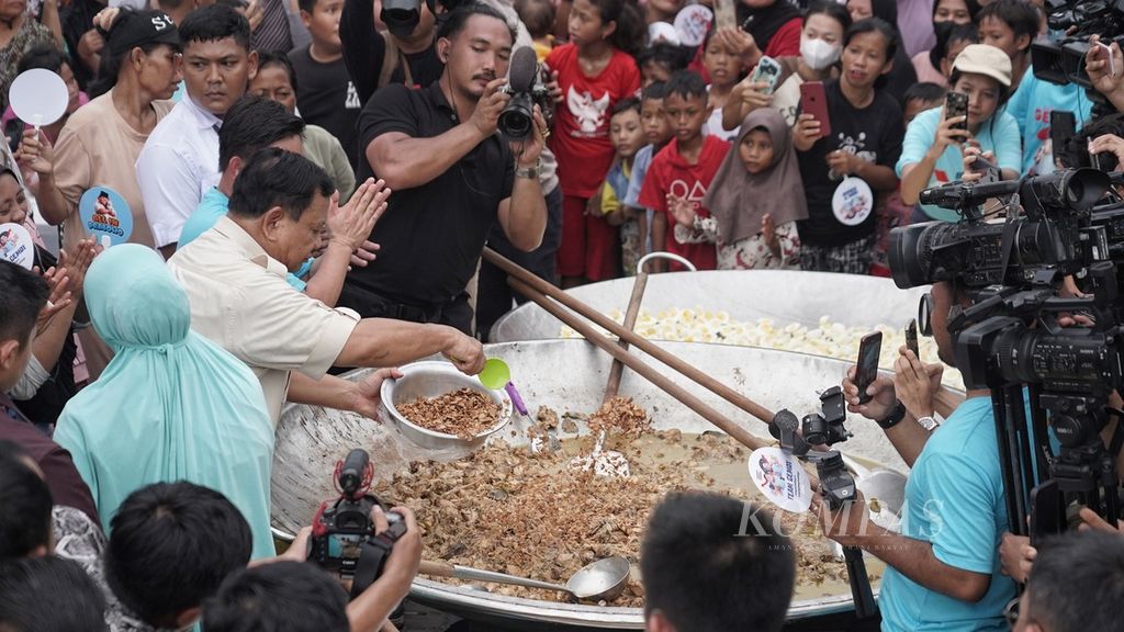 Calon presiden Prabowo Subianto menambahkan potongan daging pada masakan opor ayam dalam wajan raksasa saat berkampanye di Saung Kita, Cilincing, Jakarta Utara, Jumat (8/12/2023). 
