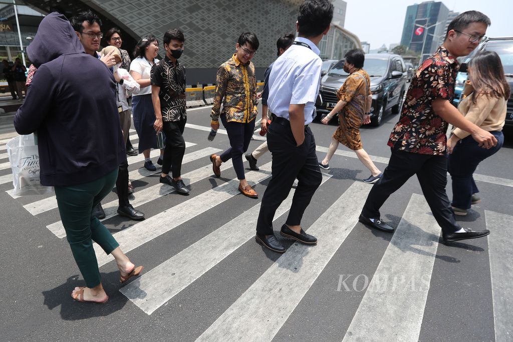 Pejalan kaki menyeberang di Jalan MH Thamrin, Jakarta, Senin (9/10/2023). 