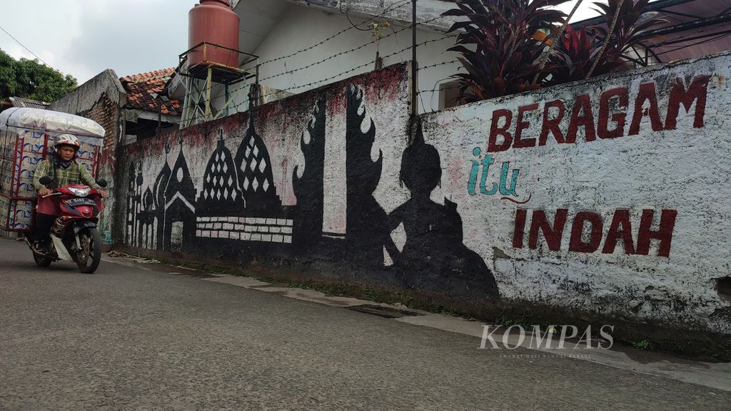 Mural bertema toleransi beragama terpampang di sebuah gang di kawasan Pondok Labu, Jakarta, Rabu (6/7/2022). Di tengah masyarakat Indonesia yang majemuk, praktik moderasi beragama harus terus dikedepankan dan menjadi kebutuhan nyata bangsa yang agamis. 