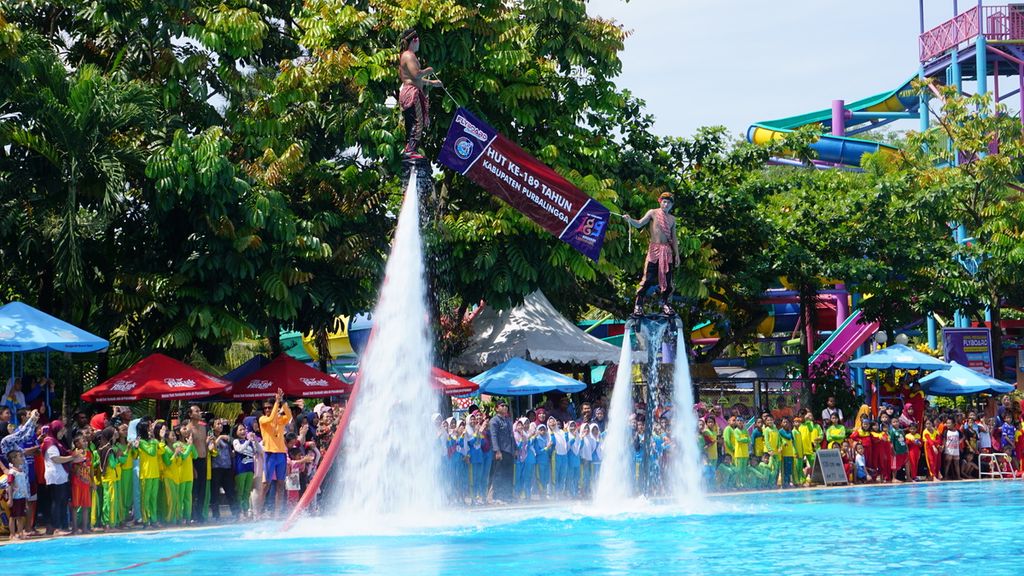 Para pemain <i>flyboard </i>terbang membentangkan spanduk HUT Purbalingga di obyek wisata Owabong, Purbalingga, Jawa Tengah, Rabu (18/12/2019).