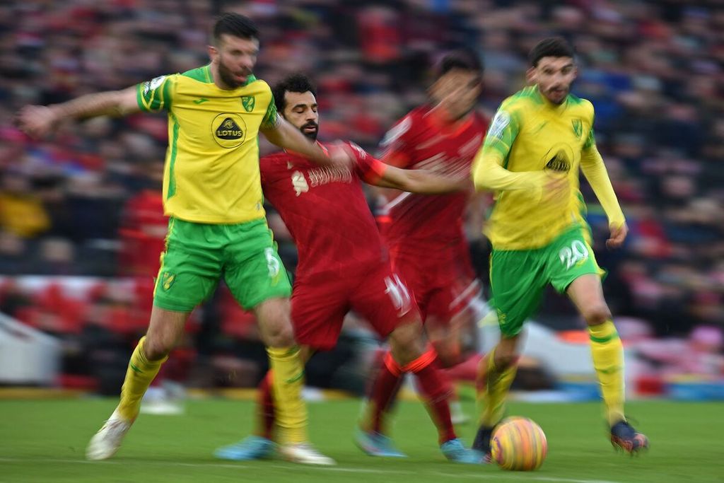 Pemain Liverpool, Mohamed Salah (tengah) berebut bola dengan para pemain Norwich City, dalam pertandingan Liga Inggris antara Liverpool dan Norwich City di Stadion Anfield, Liverpool, Sabtu (19/2/2022). Liverpool mengalahkan Norwich City, 3-1, setelah tertinggal 0-1.