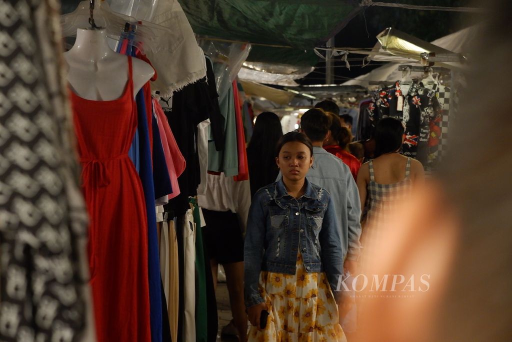 Seorang anak berjalan di antara tenda-tenda pedagang yang berjualan di Night Market, Kamboja, Rabu (3/5/2023). Night Market adalah satu-satunya pasar malam yang buka saat malam hari di Phnom Penh. Tempat ini banyak dikunjungi wisatawan dari dalam dan luar negeri untuk membeli oleh-oleh dan mencari hiburan malam.