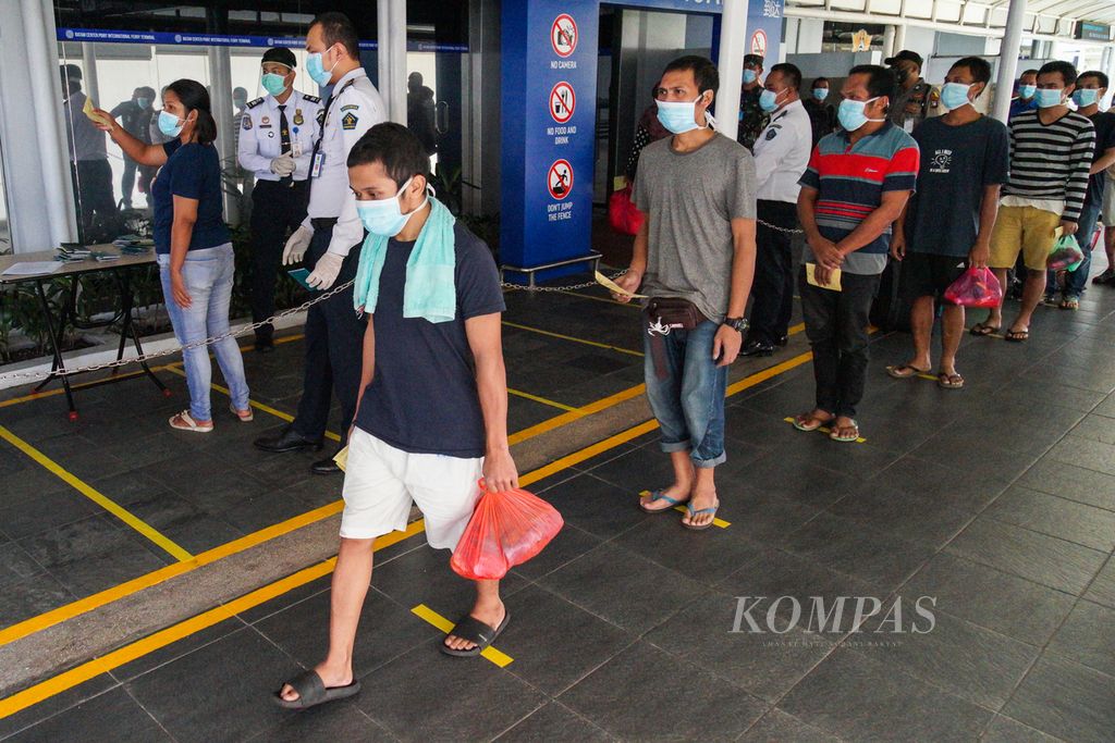 Para pekerja migran Indonesia berbaris menunggu pemeriksaan kesehatan dan dokumen imigrasi di Pelabuhan Internasional Batam Centre, Kota Batam, Kepulauan Riau, Kamis (21/5/2020).