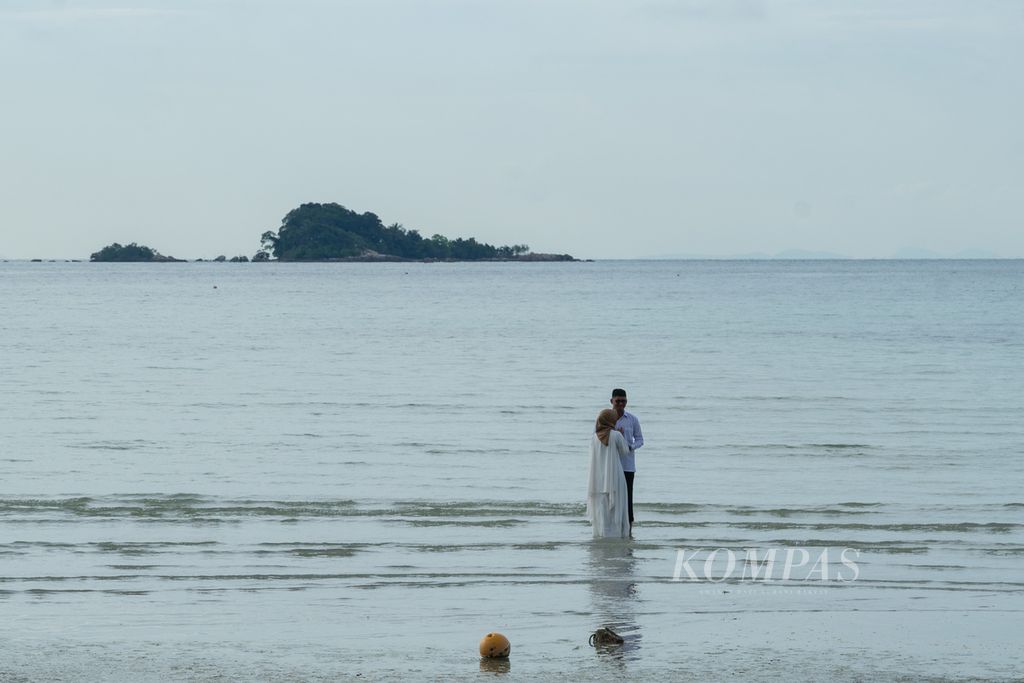 Sepasang calon pengantin mengikuti sesi foto di tengah sepinya suasana Lagoy Bay yang termasuk dalam Kawasan Strategis Pariwisata Nasional Lagoi, Kabupaten Bintan, Kepulauan Riau, Senin (18/10/2021).