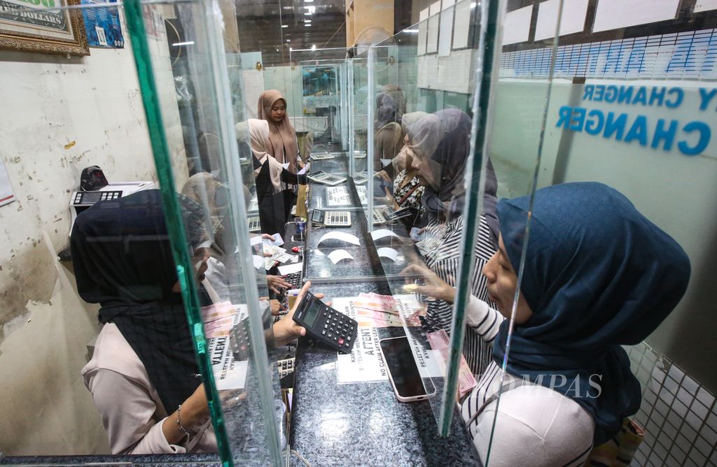 Officers serve foreign exchange transactions at PT Valuta Artha Mas in Jakarta, Tuesday (16/4/2024). The exchange rate of the rupiah was recorded to weaken, breaking through the level of Rp 16,200 per US dollar after the 2024 Eid holiday.
