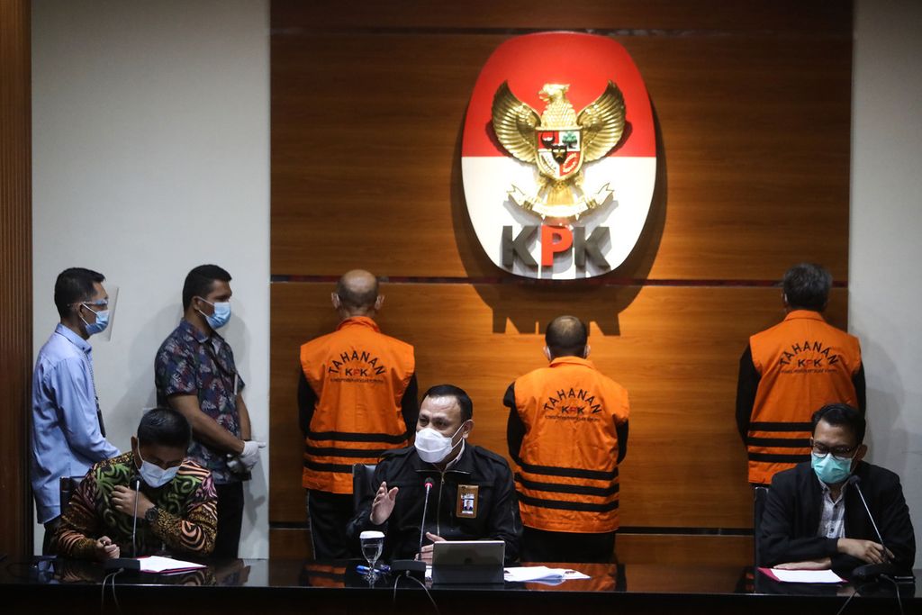 Ketua Komisi Pemberantasan Korupsi (KPK) Firli Bahuri menyampaikan keterangan terkait operasi tangkap tangan yang melibatkan Gubernur Sulawesi Selatan Nurdin Abdullah (berdiri, kanan) di Gedung KPK, Jakarta, Minggu (28/2/2021) dini hari. Selain Nurdin Abdullah, KPK juga menahan dua tersangka lainnya terkait operasi tangkap tangan yang dilakukan di Makassar pada Sabtu (27/2/2021) dini hari. Nurdin ditetapkan sebagai tersangka dalam kasus dugaan suap proyek infrastruktur. 