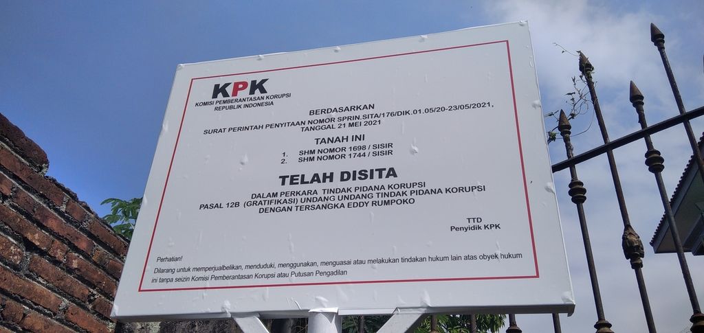 Sebuah plang tanda sita yang dipasang oleh Komisi Pemberantasan Korupsi awal Juni 2021 terpampang jelas di tepi sebuah lahan kosong di Jalan Sultan Agung Nomor 7 Batu, Jawa Timur. Plang ini dipasang terkait perkara gratifikasi di Pemerintah Kota Batu pada tahun 2011-2017. Foto diambil 3 Juni 2021.