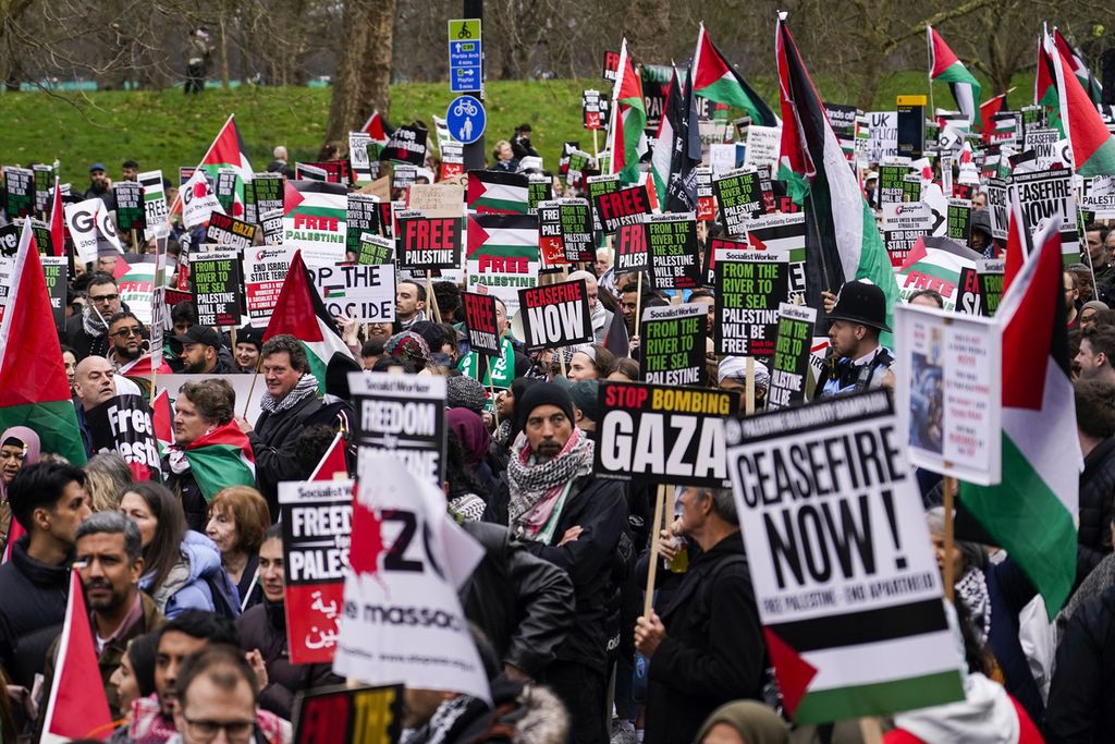 Para pengunjuk rasa mengibarkan bendera dan plakat saat demonstrasi mendukung rakyat Palestina di Gaza, di London, Inggris, 17 Februari 2024. 