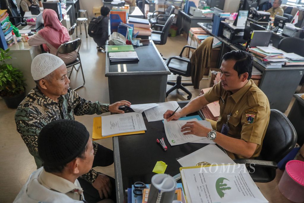 Aparatur sipil negara (ASN) melayani warga di Badan Kepegawaian Daerah, kompleks Balai Kota DKI Jakarta, Senin (21/8/2023). 
