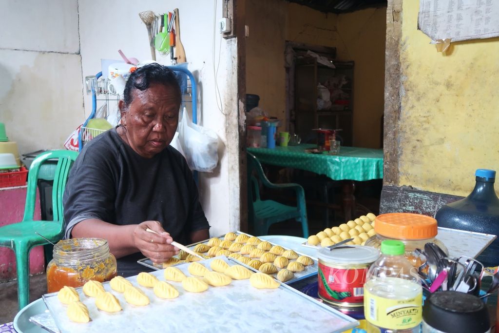 Ellen Masael (66), warga Kampung Islam, Tuminting, Manado, Sulawesi Utara, tengah membuat kue kering untuk menyambut Natal 2022 pada Rabu (14/12/2022) sore. Ellen adalah warga Nasrani yang tinggal di Kampung Islam.