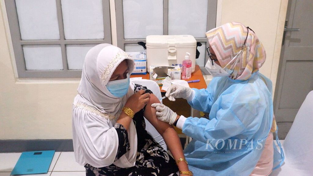Seorang warga menerima vaksinasi Covid-19 di Balai Pengobatan Pangkalan TNI Angkatan Laut Banjarmasin, Kalimantan Selatan, Jumat (17/9/2021). 