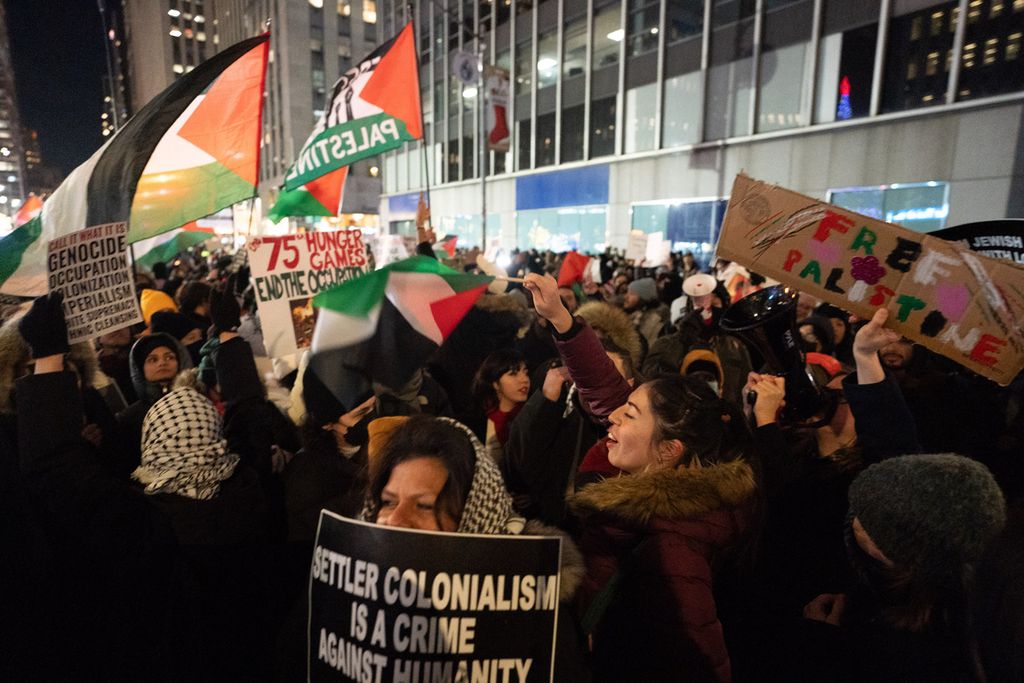 Pengunjuk rasa pro-Palestina beraksi di dekat acara penyalaan pohon Natal di Rockefeller Center di Manhattan, New York, Amerika Serikat, Rabu (29/11/2023). 