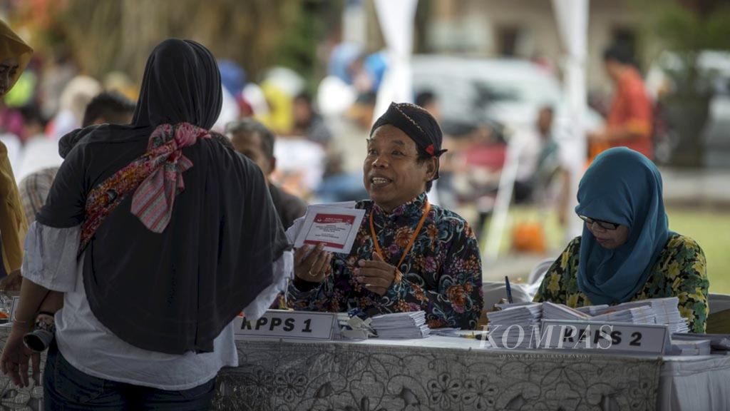 Petugas Kelompok Penyelenggara Pemungutan Suara (KPPS) memberikan surat suara kepada warga yang mengikuti simulasi pemungutan suara yang digelar oleh Komisi Pemilihan Umum Kota Magelang di Alun-alun Kota Magelang, Jawa Tengah, Kamis (28/3/2019). 