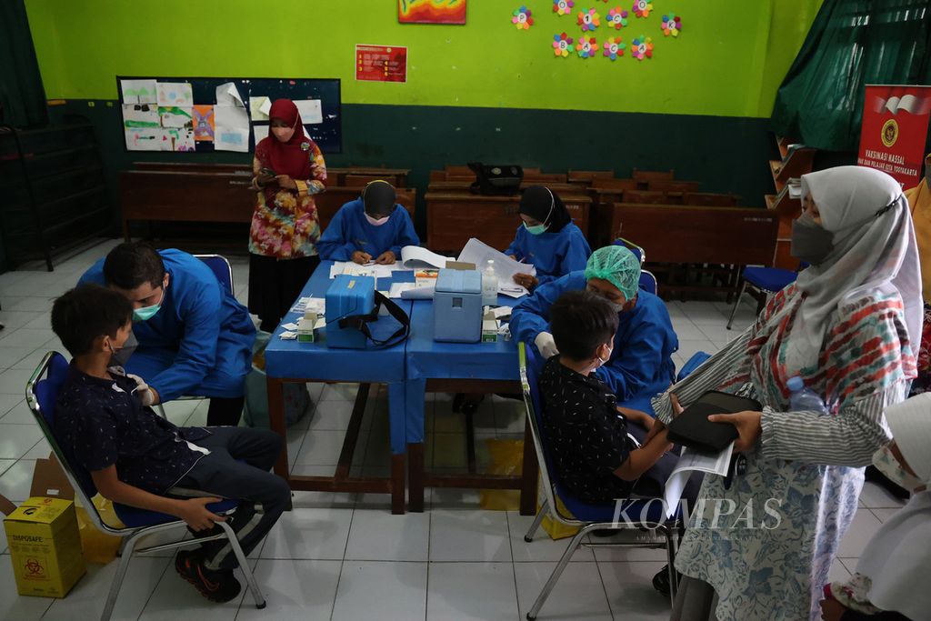 Murid mendapat suntikan vaksin Covid-19 di SD Masjid Syuhada, Gondokusuman, Yogyakarta, Selasa (8/2/2022). Sekitar 250 murid sekolah itu pada hari tersebut mendapat suntikan dosis kedua vaksin Covid-19. 
