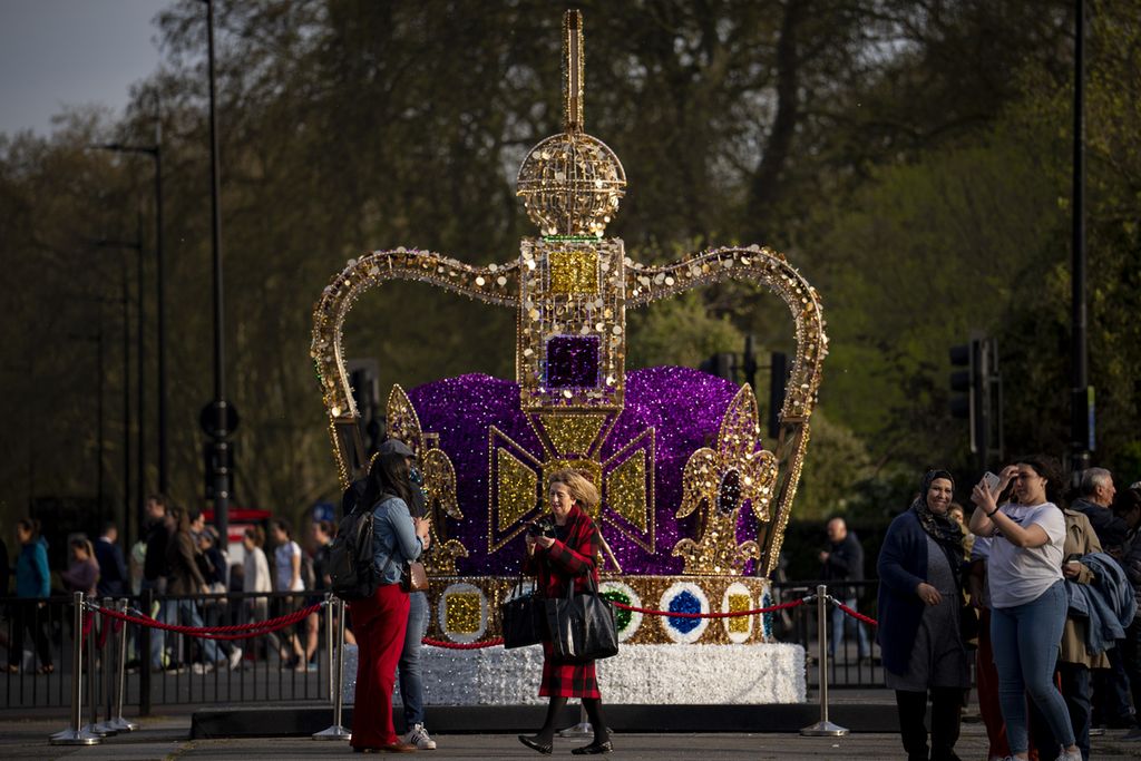 Warga berjalan melewati instalasi seni yang menggambarkan mahkota St Edward di pusat kota London, Rabu (3/5/2023). Penobatan Raja Charles III akan berlangsung di Westminster Abbey pada 6 Mei 2023. 