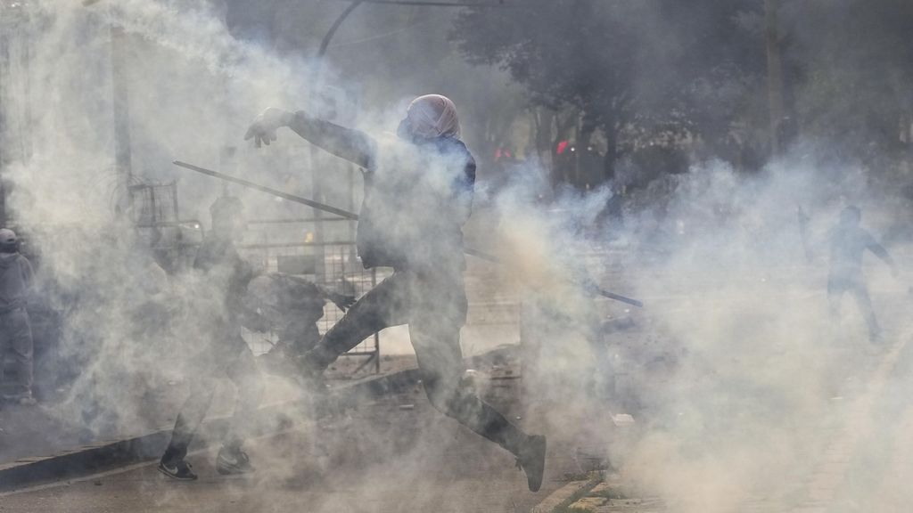 Seorang demonstran melemparkan kembali tabung gas air mata yang ditembakkan polisi saat membubarkan unjuk rasa di pusat kota Quito, Ekuador, Kamis (23/6/2022) waktu setempat. Sudah empat pengunjuk rasa tewas sejak dimulainya demonstrasi ini 13 juni lalu