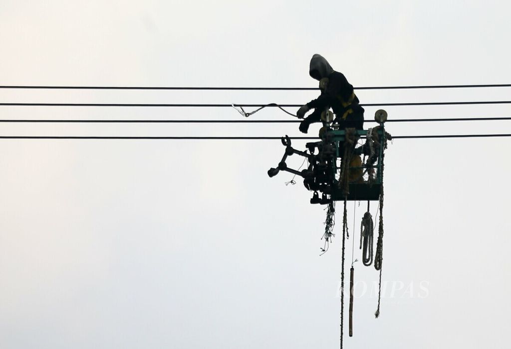 Petugas bergelantungan di saluran udara tegangan ekstra tinggi (SUTET) untuk melakukan pemeliharaan jaringan di kawasan Setu, Tangerang Selatan, Banten, Jumat (12/7/2019). 