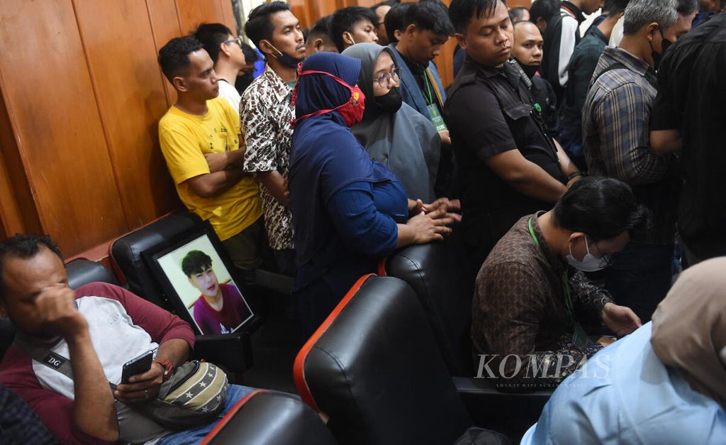 Foto korban tewas Hendra (16) diletakkan di bangku pengunjung oleh ibunnya Susiani yang menghadiri sidang pembacaan putusan dalam Kasus Tragedi Kanjuruhan di Pengadilan Negeri Surabaya, Jawa Timur, Kamis (16/3/2023). 