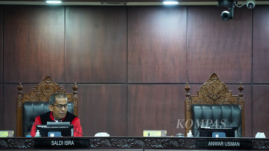 Kursi Ketua Mahkamah Konstitusi Anwar Usman (kanan) kosong saat hakim MK Saldi Isra (kiri) membacakan pendapat berbeda (<i>dissenting opinion</i>) atas putusan dikabulkannya calon presiden (capres) dan calon wakil presiden (cawapres) di bawah 40 tahun dengan syarat berpengalaman sebagai kepala daerah, di Mahkamah Konstitusi, Jakarta, Senin (16/10/2023). 