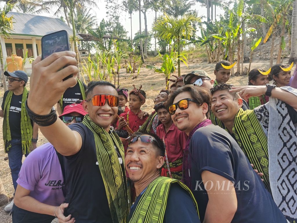 Para pelari peserta Jelajah Timur 2023 berfoto bersama dengan dengan anak-anak dan tokoh masyarakat di Desa Naileu, Kecamatan Kie, Kabupaten Timor Tengah Selatan, Nusa Tenggara Timur, Kamis (26/10/2023) siang. 