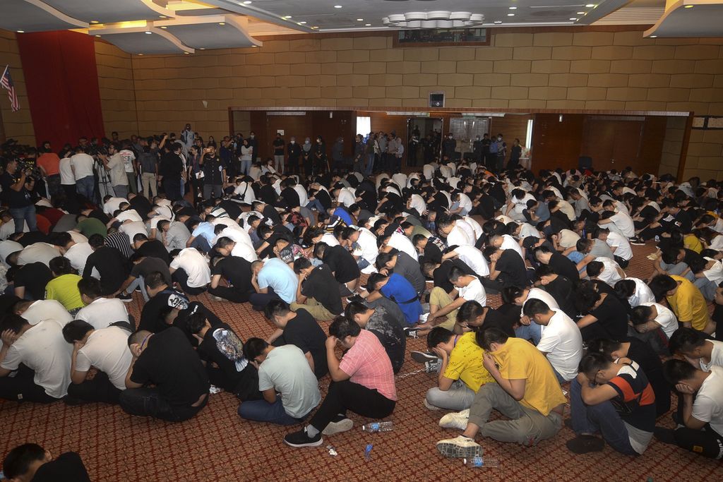 Para tahanan duduk di lantai aula di Putrajaya, Malaysia, 21 November 2019. Departemen Imigrasi Malaysia membubarkan sindikat penipuan investasi daring yang berbasis di China dengan menangkap 680 tersangka warga negara China. 