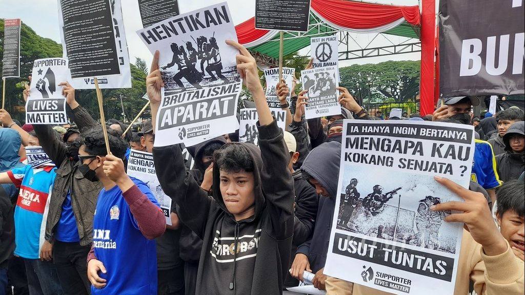 Sejumlah poster bernada tuntutan mewarnai aksi oleh seribuan Aremania di depan Bala Kota Malang, Jawa Timur, Kamis (27/10/2022). Mereka menuntut proses hukum yang adil terkait dengan Tragedi Kanjuruhan yang menewaskan 135 orang dan ratusan lainnya terluka itu.