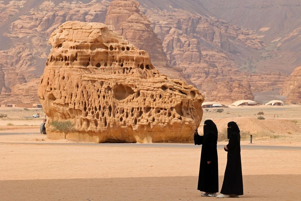 Two women are taking photos in the Al-Ula region, a UNESCO World Heritage site in Northwestern Saudi Arabia, on February 19, 2023.