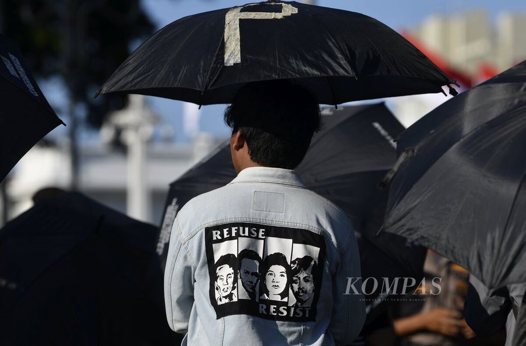 Gambar sejumlah tokoh yang menjadi korban pelanggaran HAM, antara lain Wiji Tukul, aktivis buruh Marsinah, dan aktivis HAM Munir, terlihat pada jaket yang dikenakan peserta aksi diam Kamisan ke-619 di depan Istana Merdeka, Jakarta, Kamis (23/1/2020). 