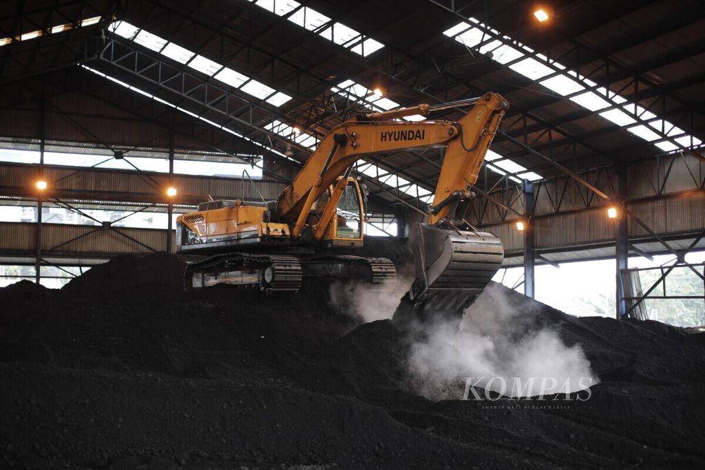 Alat berat mencampur batubara dengan cangkang sawit di Pembangkit Listrik Tenaga Uap (PLTU) Sintang, Kabupaten Sintang, Kalimantan Barat, Senin (11/10/2021). PLTU Sintang salah salah satu lokasi yang memiliki ketersediaan bahan bakar <i>co-firing</i> dalam hal ini cangkang sawit yang besar. Penghematan bahan bakar batu bara dapat dihemat hingga 10 persen dengan metode <i>co-firing </i>menggunakan cangkang sawit.