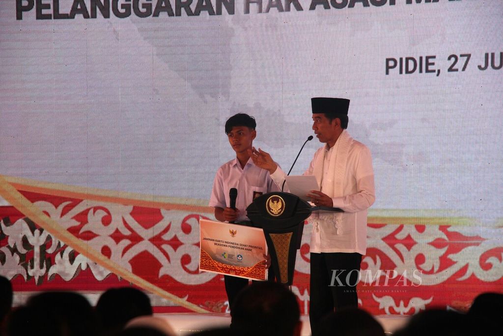 Presiden Joko Widodo berfoto bersama perwakilan dari para korban atau ahli waris korban pelanggaran hak asasi manusia (HAM) berat saat acara peluncuran program penyelesaian non-yudisial di Pidie, Aceh, Selasa (27/6/2023). 