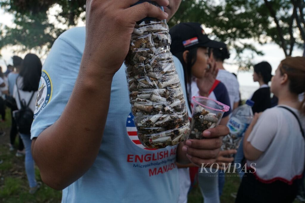 Mahasiswa mengumpulkan puntung rokok dari taman kawasan Megamas di tepi Teluk Manado, Sabtu (11/5/2019).
