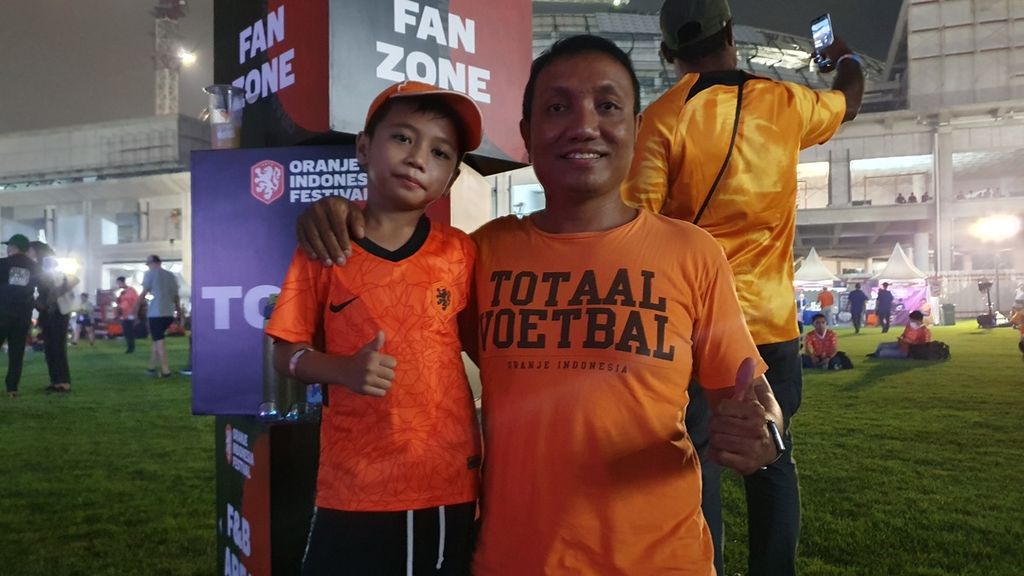 Pendukung tim nasional Belanda, Antarez, bersama anaknya, Gavi, saat mengikuti acara nonton bareng pertandingan Piala Dunia Qatar 2022 antara Belanda dan Ekuador di Festival Oranje Indonesia di Lapangan Panahan, kompleks Gelora Bung Karno (GBK), Jakarta, Jumat (25/11/2022).