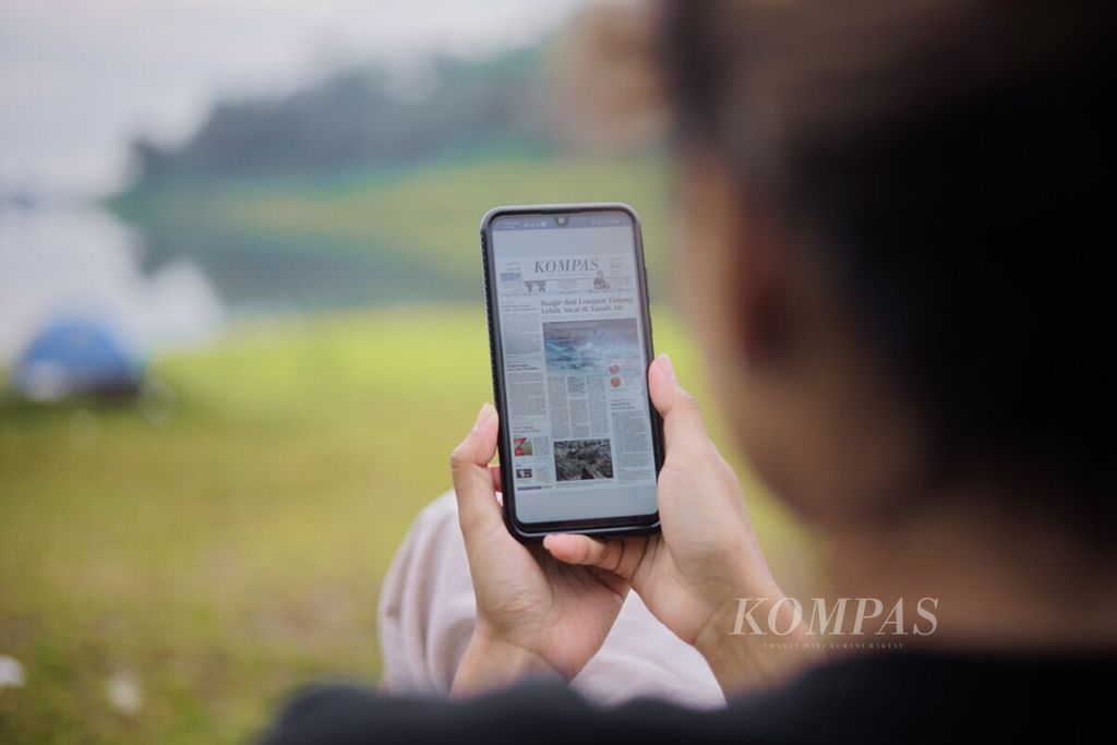 Pembaca mengakses berita digital berupa e-paper Kompas dari layanan berita berbayar kompas.id. Audiens dapat mengakses berita dimana saja dan kapan saja dengan adanya berita digital (8/11/2022). Kontribusi audiens dengan menjadi pelanggan digital dibutuhkan untuk menjaga jurnalisme berkualitas di Indonesia.