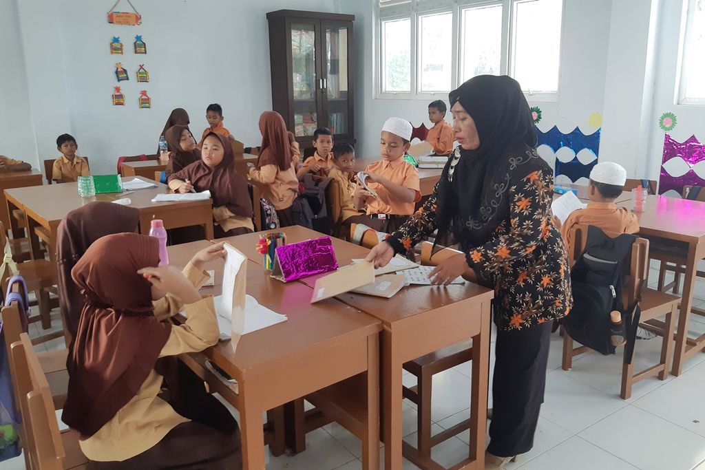 Agustina, an honorary teacher at SD N 70 Banda Aceh, is teaching her students. Agustina has been an honorary teacher since 2010 and earns Rp 400,000 per month.