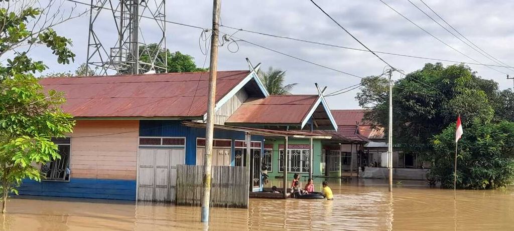 Warga Tumbang Samba, Kecamatan Katingan Tengah, Kabupaten Katingan, Kalimantan Tengah, bermain di banjir yang sudah melanda selama lebih kurang tiga hari, pada Minggu (7/8/2022).